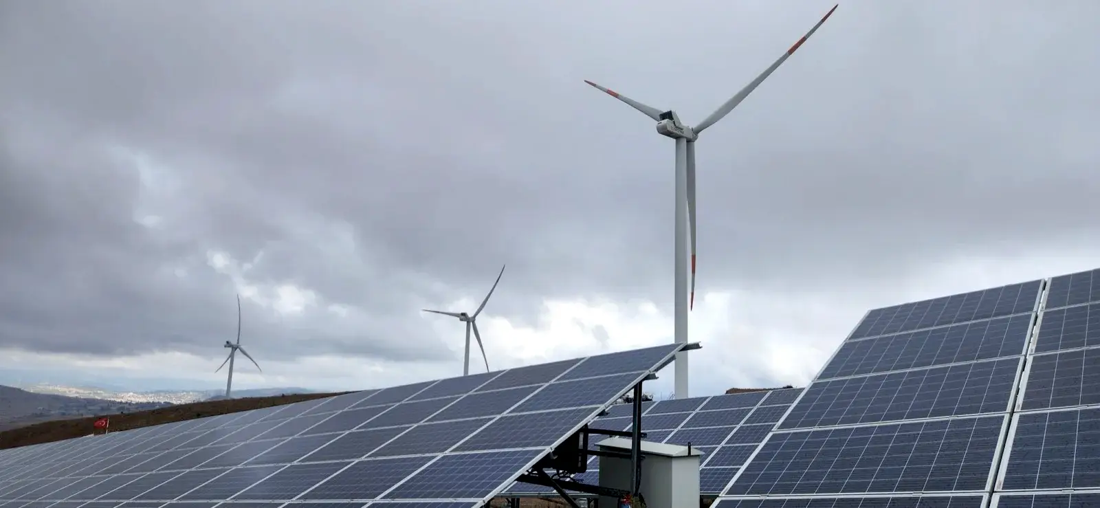 Arazi güneş enerjisi santrali — panel sahası ve rüzgar türbinleri